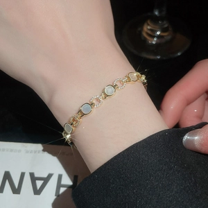 Détail bracelet doré serti de diamants pavés et incrustations rondes en nacre