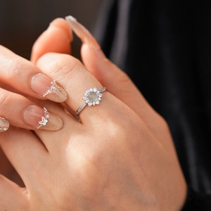 Detailed view of vintage sun flower ring with light green stone and zircon on finger