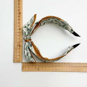 Wide paisley satin headband with bow knot and measurement ruler on white background