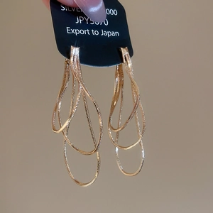 Vue détaillée des boucles d'oreilles multi-couches à franges dorées en argent S925