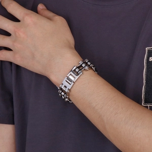 Close-up of a silver and black two-tone bicycle chain link bracelet on a male wrist