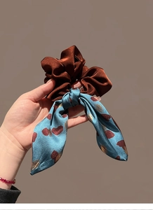 Close-up of vintage satin scrunchie and floral ribbon with heart print details