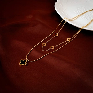 Détail du collier trèfle à double couche avec insert noir sur velours rouge