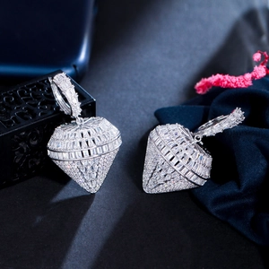 Dettaglio di orecchini a cuore in argento con micro-pavé di zirconi e design 3D