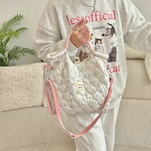 Detailed shot of white quilted tote bag featuring rabbit prints and pink shoulder strap