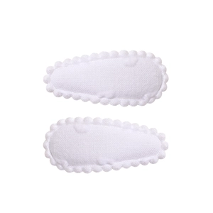 Detail of two white fabric BB hair clips with delicate wavy lace edges on a clean background