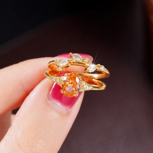 Macro detail of gold floral ring set with orange gemstone and marquise-cut diamonds