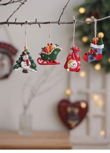 Close-up of resin Christmas ornaments hanging on branches with warm home background