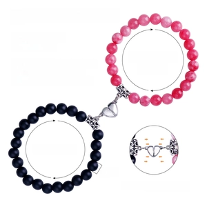 Detail of 8mm natural stone couple bracelets with magnetic heart charm and adjustable cord
