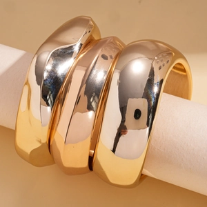 Three-piece set of chunky gold-plated geometric rings with polished wavy designs