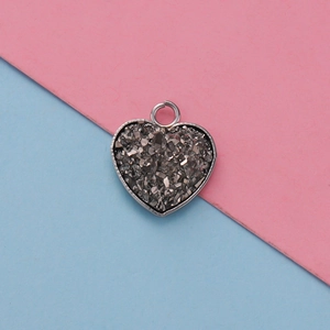 Detail of 13mm heart pendant tray with shimmering glitter resin on a pastel background