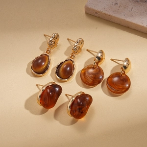 Detail of vintage resin earring set featuring brown marble and amber patterns on gold base