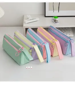 Detailed view of five macaron-colored canvas pencil bags with double zippers and ring pulls