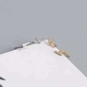 Macro shot of minimalist lightning bolt stud earrings with sparkling cubic zirconia stones