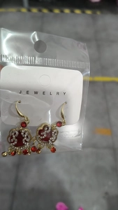 Detail of Chinese style tassel earrings with red heart stones and gold flower accents
