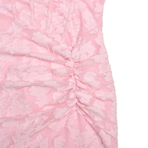 Dettaglio del tessuto a rete rosa con motivo floreale 3D e eleganti arricciature