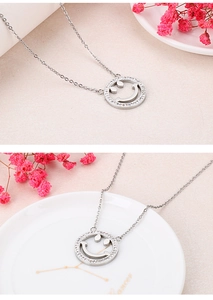 Close-up of silver hollow smiley face pendant necklace with sparkly rhinestones