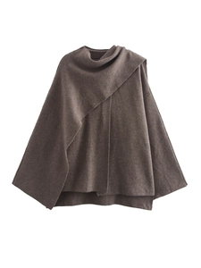 Detailed view of a brown knit cape coat with an asymmetric drape and high neck design