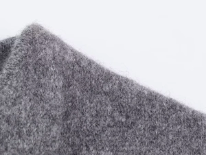 Dettaglio macro della trama soffice e della lana pregiata di questo cappotto grigio