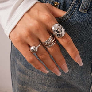 Detailed view of silver minimalist metal rings featuring geometric bean and layered designs