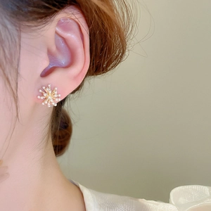 Gros plan détaillé de boucles d'oreilles perles feu d'artifice dorées sur modèle