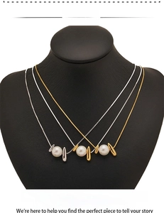 Detail view of gold and silver layered necklaces with pearls and metallic teardrop pendants