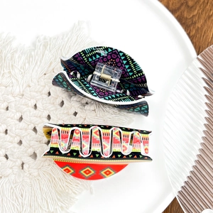 Bohemian acrylic hair claw clips with colorful Aztec patterns on a ceramic display