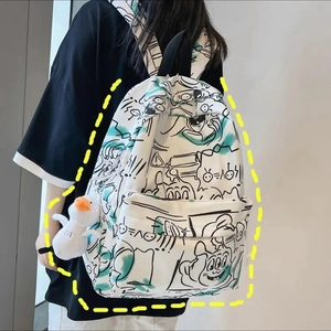 Detail view of white graffiti backpack with cute duck plush charm and side pocket