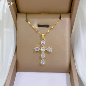 Close-up of a gold cross pendant set with pear-cut zircons in a jewelry gift box