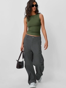 Dettaglio del top senza maniche verde militare e pantaloni cargo grigi multitasche