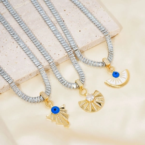 Detailed macro view of three gold evil eye pendants with sparkling clear zircons and tennis chains