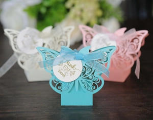 Detail of laser-cut butterfly wedding favors in blue, pink, and white pearl paper