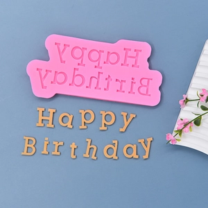 Pink silicone Happy Birthday cake mold for fondant baking on a blue background