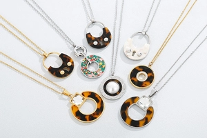 Flat lay of retro stainless steel necklaces with acetate charms and pearl crystals