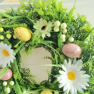 Easter wreath with white daisies, colorful eggs, and green leaves for festive door decor