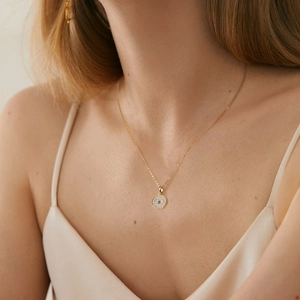 Elegant gold necklace with geometric Evil Eye pendant and blue stone on model