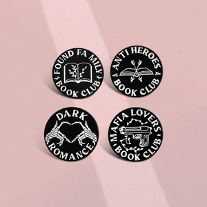 Set of four geometric book club enamel pins in black and white on a pink background