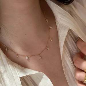 Detail view of two-tone gold Vatican cross necklace with zircon and metal teardrops