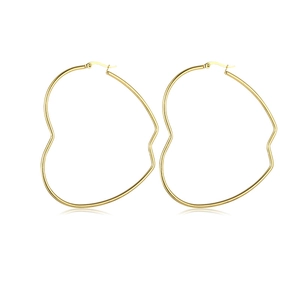 Close-up of oversized golden heart hoop earrings with irregular wavy polished finish