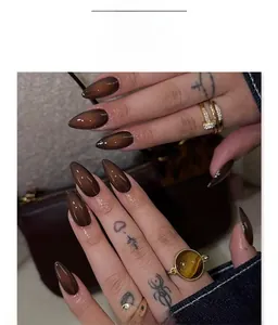 Macro detail of almond-shaped cat eye press-on nails in deep brown glossy finish