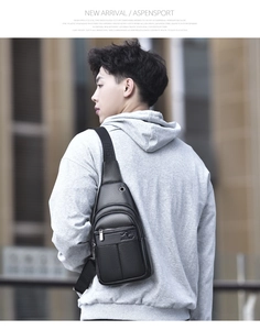 Detail of the litchi texture leather texture and brand logo on the black chest bag
