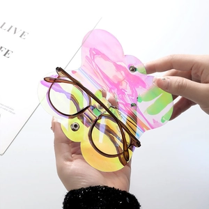 Iridescent laser butterfly glasses pouch with brown tortoiseshell sunglasses in hand