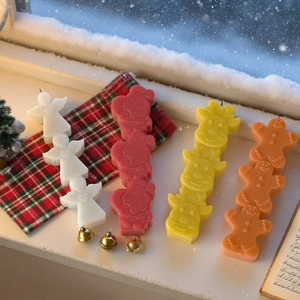 Stacked Christmas silicone molds for candles featuring angel elk and gingerbread man shapes