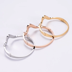 Detailed side view of wave-shaped polished metal bracelets in silver, gold, and rose gold
