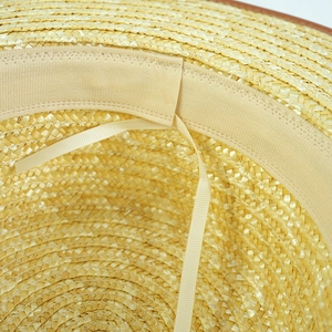 Detail of straw sun hat interior featuring a knit sweatband and adjustable drawstring