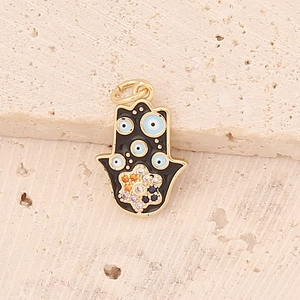 Detailed close-up of a Hamsa hand pendant with blue evil eye patterns on a stone base