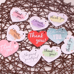 Colorful heart-shaped thank you gift cards with watercolor designs on woven mat