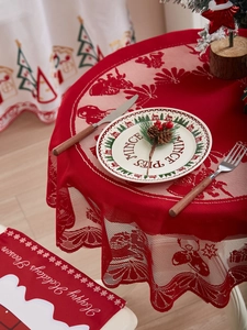 Detail of red Christmas lace tablecloth with reindeer patterns and festive table runner