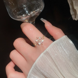 Detailansicht eines goldenen Blumenrings mit rosa Zirkonias und funkelnden Effekten