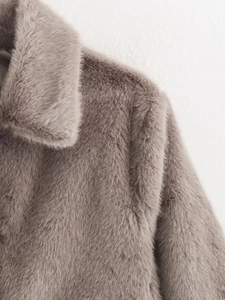 Detail of taupe faux fur coat showing soft plush texture and collar design on a hanger